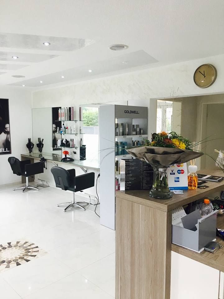 sauberes Kosmetikstudio in Aarburg mit einem grossen Spiegel und zwei Friseur-Stühlen und einer Theke im Vordergrund, auf der ein Blumenstrauss steht