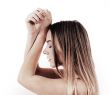 Frau mit blond-braunen Strähnen und geschlossenen Augen, die sich wohl fühlt