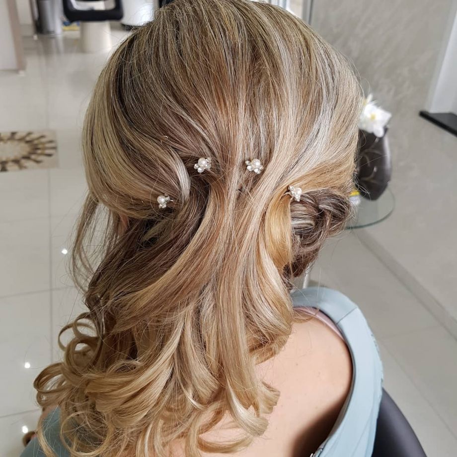 Hochzeitsfrisur einer Frau mit blonden leicht gelockten geschmückten Haaren